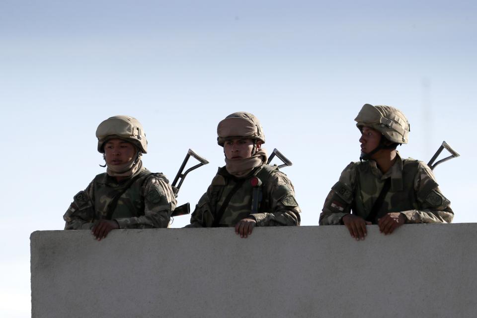 Soldiers guard the road to the "Yacimientos Petroliferos Fiscales Bolivianos" plant that has been blocked by former President Evo Morales' supporters in El Alto, Bolivia, Sunday, Nov. 17, 2019. Bolivia's political crisis turned deadly after security forces opened fire on supporters of former President Evo Morales in Sacaba on Nov. 15, killing multiple people and injuring dozens. (AP Photo/Natacha Pisarenko)