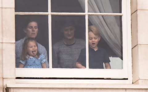 Prince George And Princess Charlotte are spotted at the window of Buckingham Palace waving and sticking their tongues out to royal fans below. - Credit: WENN.com