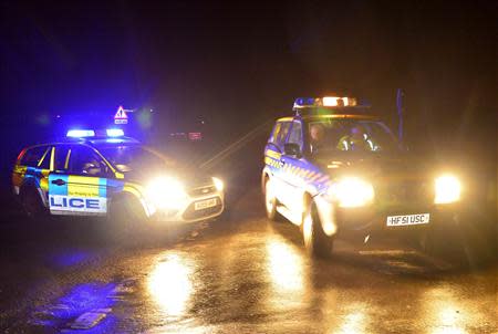 Emergency vehicles drive past a police road-block in the village of Cley in Norfolk, east England, January 8, 2014. REUTERS/Toby Melville