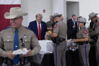 Republican presidential candidate and former President Donald Trump helps serve food to Texas National Guard soldiers, troopers and others who will be stationed at the border over Thanksgiving, Sunday, Nov. 19, 2023, in Edinburg, Texas. (AP Photo/Eric Gay)
