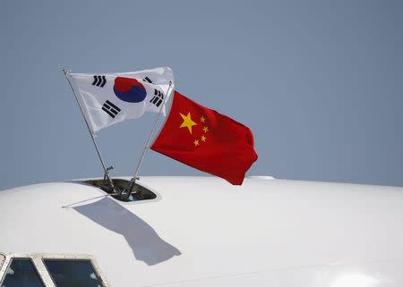 South Korea (L) and China's flags flutter atop a aircraft as South Korean President Park Geun-hye (not in picture) arrives at Beijing Capital International Airport in China, September 2, 2015, ahead of attending the commemoration of the 70th anniversary of the end of World War Two. REUTERS/Kim Kyung-Hoon