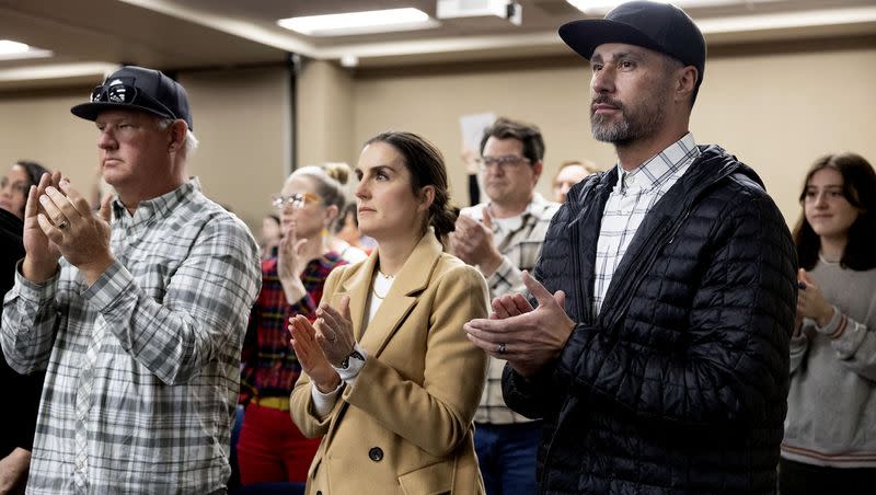 Greg Wilking, left, and Rachel and Al van der Beek applaud the Granite School Board’s resolution demanding the “immediate resignation” of Utah State Board of Education member Natalie Cline at the Granite School District in Salt Lake City on Friday, Feb. 9, 2024. Cline is facing public scrutiny for her social media posts, with the latest incident occurring on Tuesday after she posted a mocking statement on Facebook targeting a female high school basketball player. The van der Beeks’ daughter was the alleged target of Cline’s social media post. Wilking also has a daughter on the team.