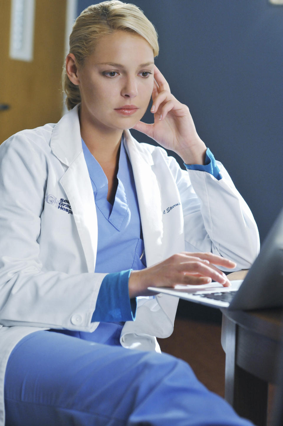 Katherine sits and looks at a computer