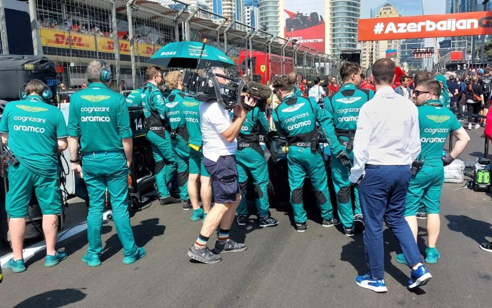 Mechanics surround the Aston Martin - Tom Cary