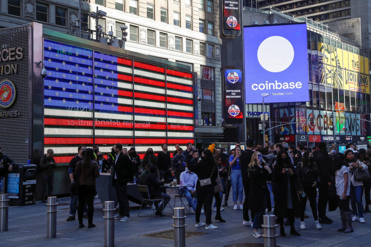 Employees of Coinbase Global Inc, the biggest U.S. cryptocurrency exchange, watch as their listing is displayed on the Nasdaq MarketSite jumbotron at Times Square in New York, U.S., April 14, 2021. REUTERS/Shannon Stapleton