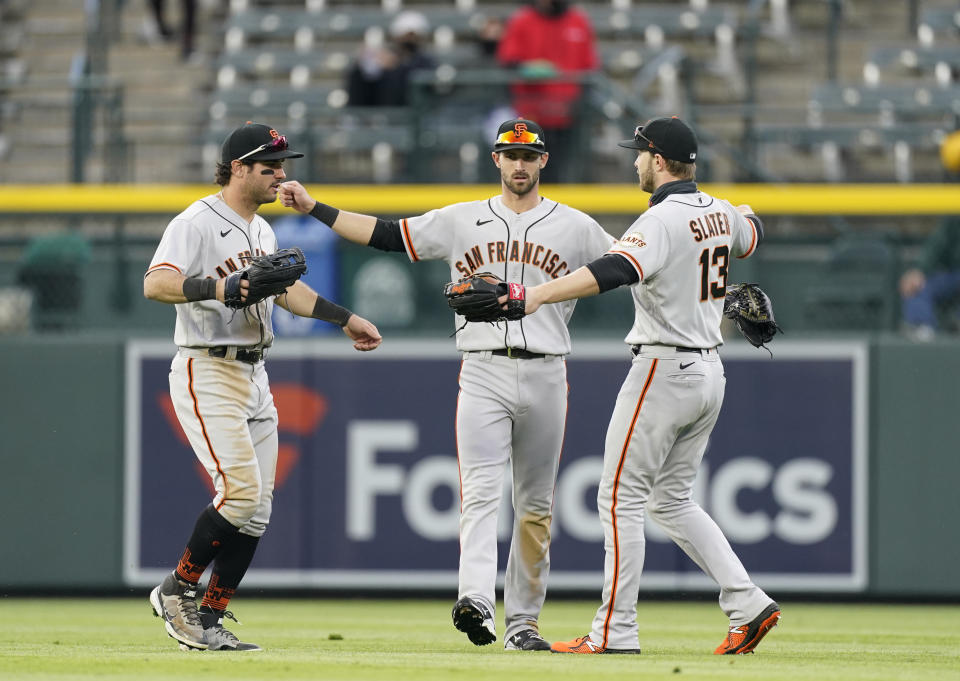 From left, San Francisco Giants left fielder Mike Tauchman, center fielder Steven Duggar and right fielder Austin Slater celebrate after the seventh inning of game one of a baseball doubleheader against the Colorado Rockies Tuesday, May 4, 2021, in Denver. The Giants won the opening game of the twinbill by a score of 12-4. (AP Photo/David Zalubowski)