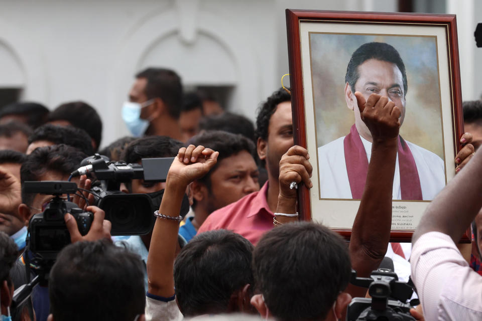 Pro-government supporters hold Prime Minister Mahinda Rajapaksa's portrait while protesting outside the  prime minister's residence on May 9, 2022 in Colombo, Sri Lanka.  / Credit: Getty Images