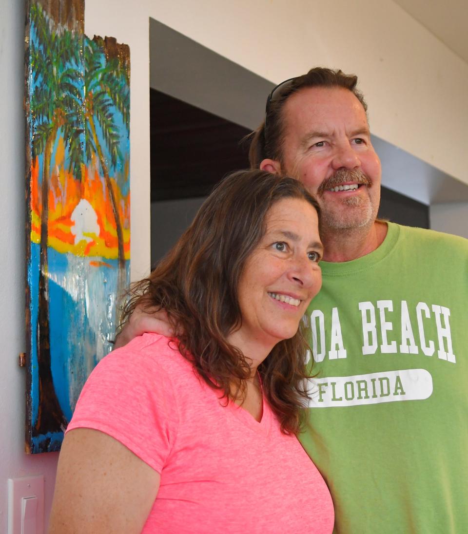 Michelle and Paige Green are pictured at home on Merritt Island. Her mother, Norma Cross, had been living with them since 2014, but died in October. The painting on a board behind them was one that Paige was working on the day Norma passed away, and she held it: Even though it was not yet completed, he has left it as is.