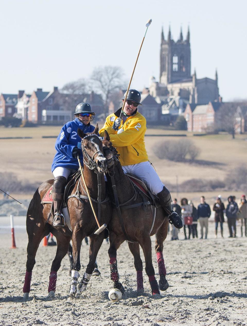 With the St. George’s School chapel serving as a backdrop, ponies run neck-and-neck during the beach polo match Saturday at Sachuest Beach in Middletown. The event, which also was held Sunday, capped the 32nd annual Newport Winter Festival. [DAVE HANSEN PHOTO]