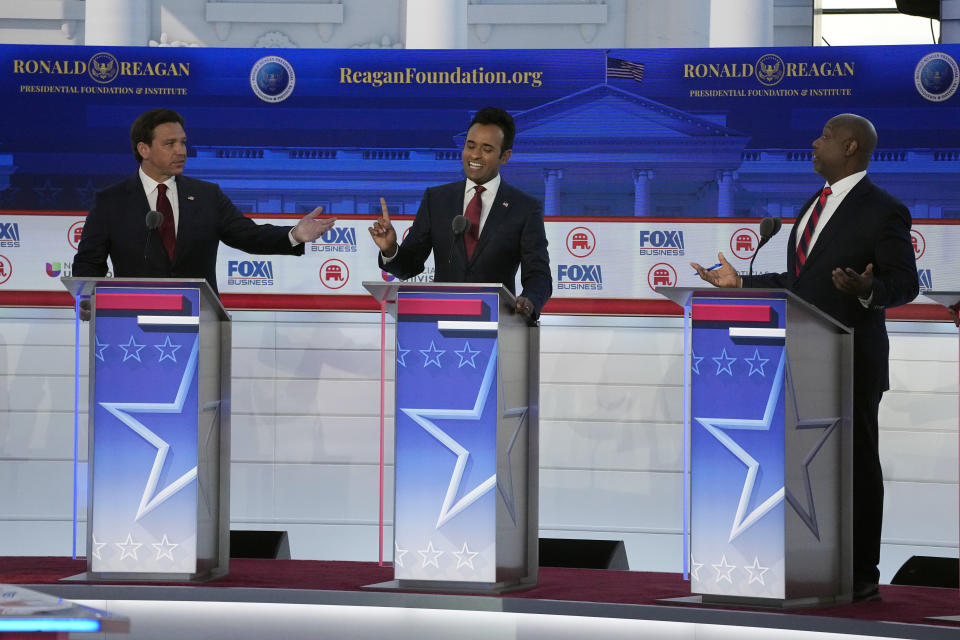 From left to right, Florida Gov. Ron DeSantis, businessman Vivek Ramaswamy and Sen. Tim Scott, R-S.C., argue a point during a Republican presidential primary debate hosted by FOX Business Network and Univision, Wednesday, Sept. 27, 2023, at the Ronald Reagan Presidential Library in Simi Valley, Calif. (AP Photo/Mark J. Terrill)