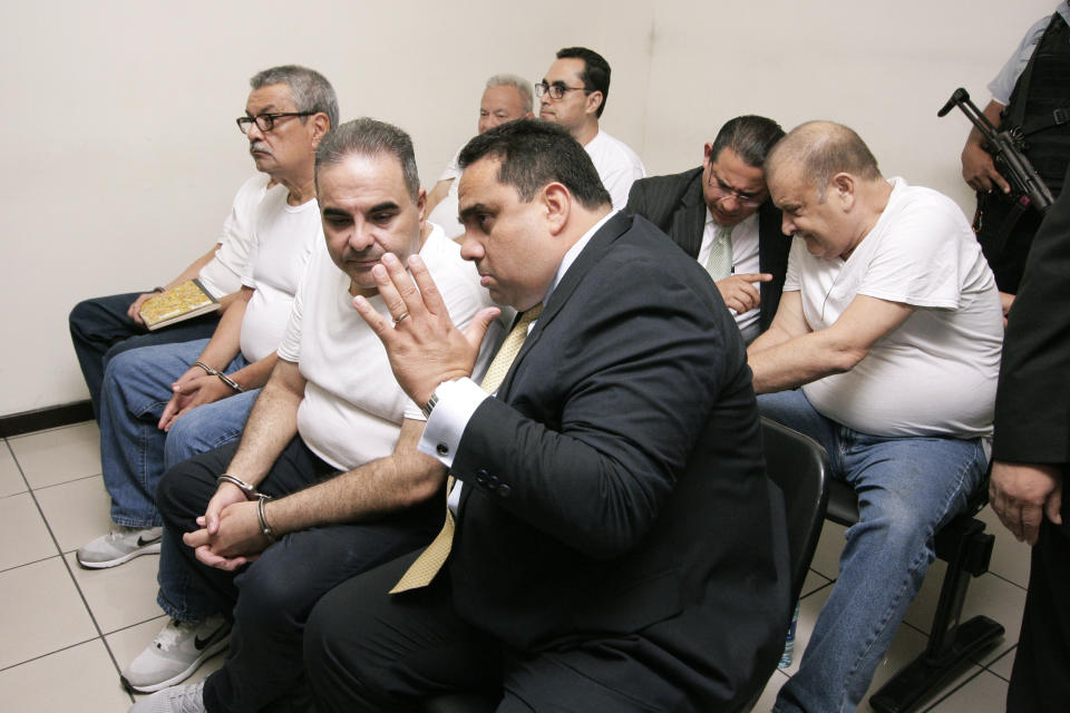 El Salvador's former President Tony Saca, center left, talks to his lawyer during an audience with a judge at the Isidro Menendez Judicial Complex in San Salvador, El Salvador, Wednesday, Sept. 12, 2018. Saca was sentenced to 10 years in prison for corruption Wednesday after pleading guilty to diverting more than $300 million in state funds. (AP Photo/Salvador Melendez)