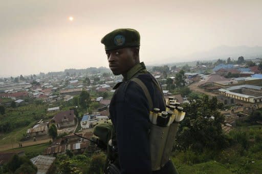 A Congolese fighter of the rebel M23 group, looks on from a hill in Bunagana, a town near the Ugandan border. Rebel fighters in the Democratic Republic of Congo seized control Sunday of more towns in the country's east, but said they would cede most of their gains to UN peacekeepers and police
