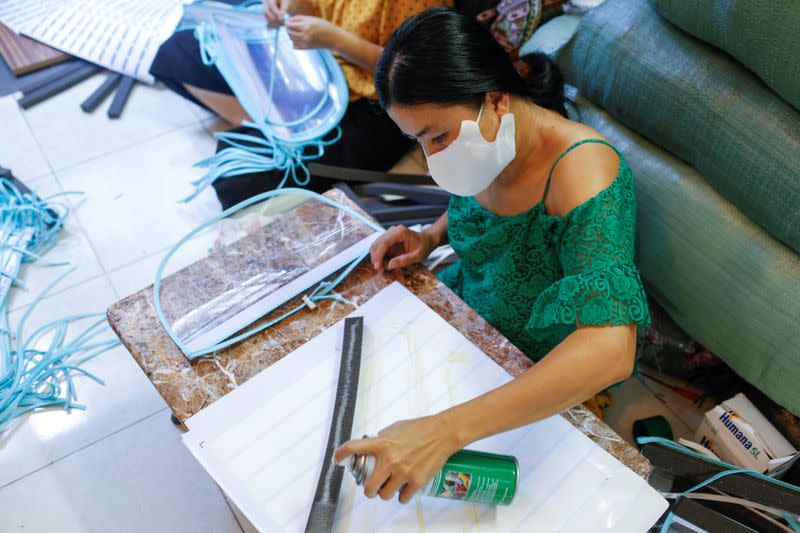 A woman makes plastic face masks during the outbreak of the coronavirus disease (COVID-19), in Ho Chi Minh, Vietnam