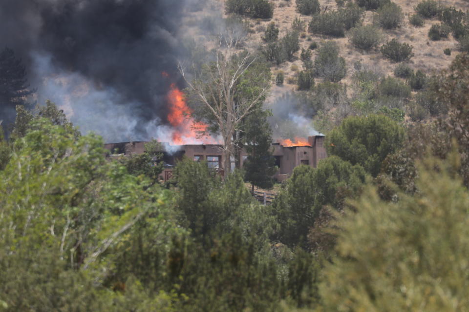 Un incendio envuelve una casa en Acton, California, el martes 1 de junio de 2021. (AP Foto/David Swanson)