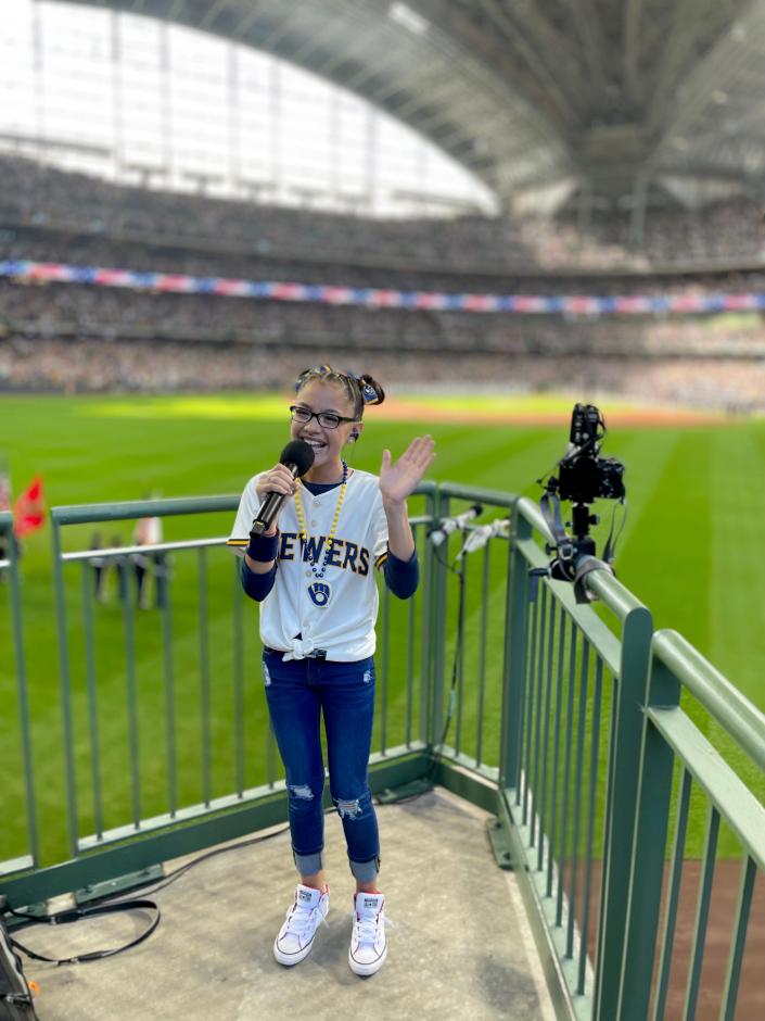 Liamani Segua, 12, of Racine sings the National Anthem before the Milwaukee Brewers&#39; playoff game against the Atlanta Braves on Oct. 8 at American Family Field in Milwaukee. The team is now seeking more singers to perform the National Anthem.