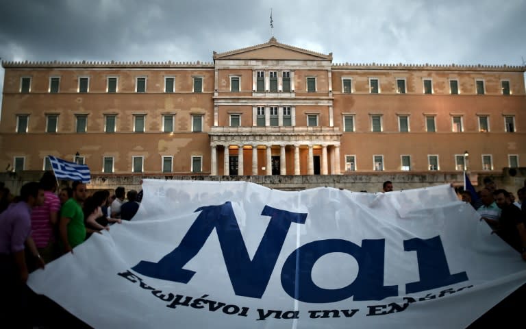 Pro-euro protesters hold a banner reading ''YES" during a demonstration in front of the parliament in Athens on June 30, 2015