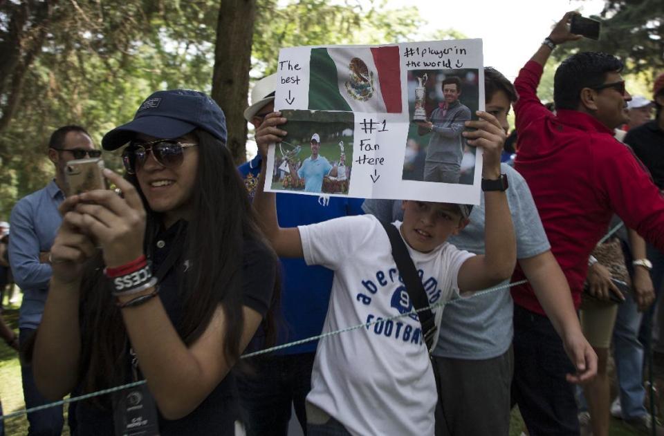 A fan of Northern Ireland golfer Rory McIlroy holds up pictures of him during the Mexico Championship at Chapultepec Golf Club in Mexico City, Sunday, March 5, 2017. All but one of the world's top 50 golfers are contesting the World Golf Championship PGA event, which this year relocated to Mexico City from the Trump National Doral Resort in Florida. (AP Photo/Christian Palma)