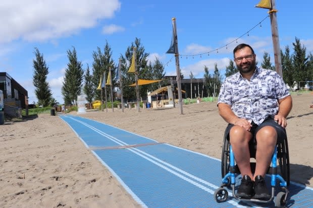 Since he started using a wheelchair 26 years ago, Maxime Boily  has struggled to cross the sand in his wheelchair. Now, with a new mat at the Baie de Beauport, Boily is able to get to the water with ease.  (Franca Mignacca/CBC  - image credit)