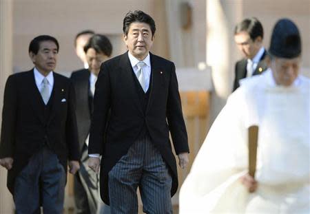 Japan's Prime Minister Shinzo Abe (C) is led by a shinto priest (R) as he pays a customary New Year's visit at Ise shrine in Ise, central Japan, in this photo taken by Kyodo January 6, 2014.REUTERS/Kyodo