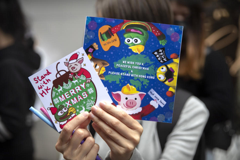 A protester holds Christmas cards for detained and jailed protesters during a rally in Hong Kong, Monday, Dec. 16, 2019. China's premier said Monday that turmoil over amendments to extradition legislation has damaged Hong Kong society on all fronts. (AP Photo/Mark Schiefelbein)