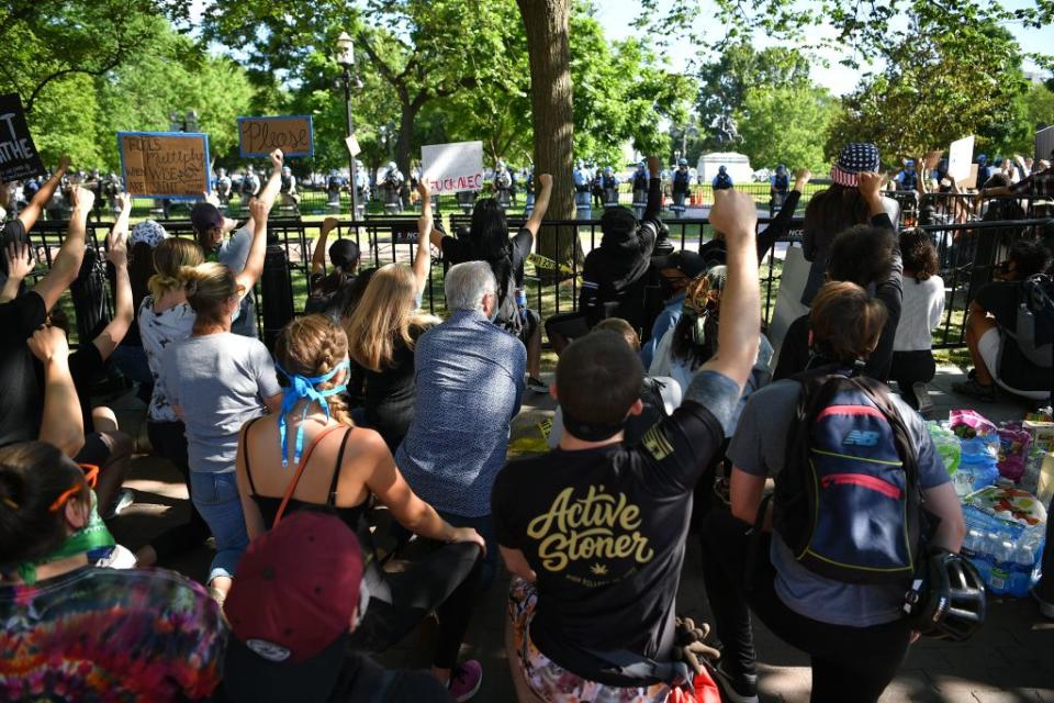 Pictured are protesters taking a knee and raising their fists in Lafayette Square near the White House in Washington, DC.