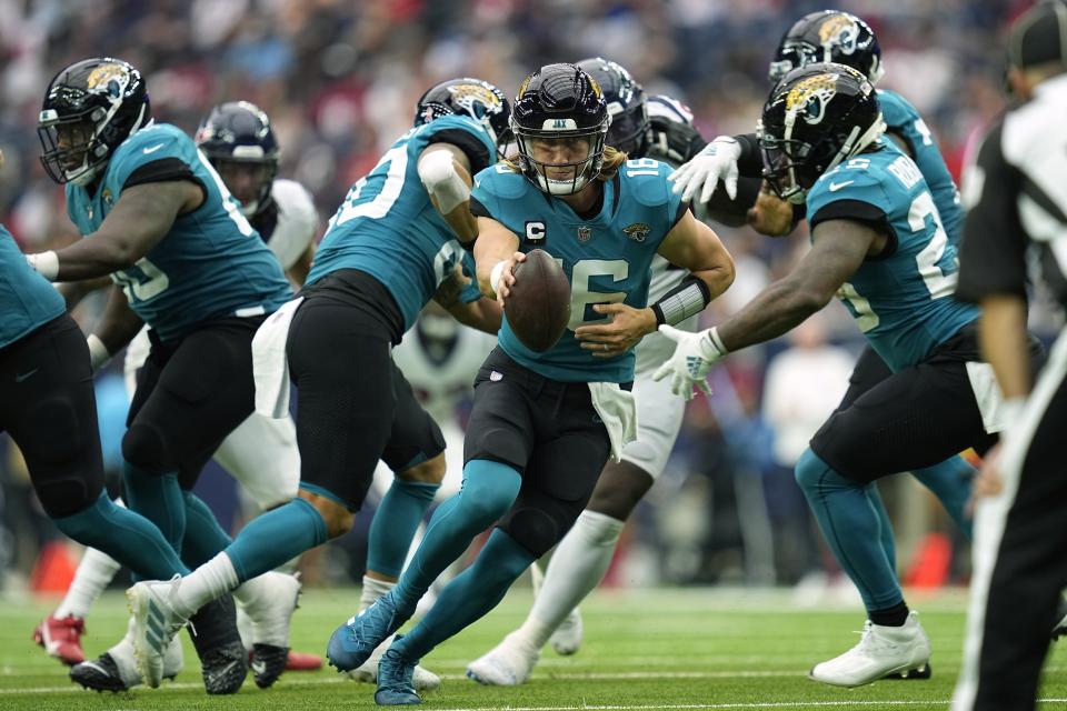 Jacksonville Jaguars quarterback Trevor Lawrence (16) reaches to hand the ball off to running back James Robinson, right, during the second half of an NFL football game against the Houston Texans Sunday, Sept. 12, 2021, in Houston. (AP Photo/Sam Craft)