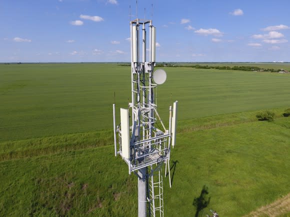 Cell tower in a large grassy field.