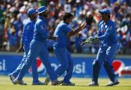 India's Mohit Sharma (C) celebrates with team mates including wicketkeeper, captain MS Dhoni (R) after Sharma caught out West Indies batsman Chris Gayle for 21 runs during their Cricket World Cup match in Perth, March 6, 2015. REUTERS/David Gray