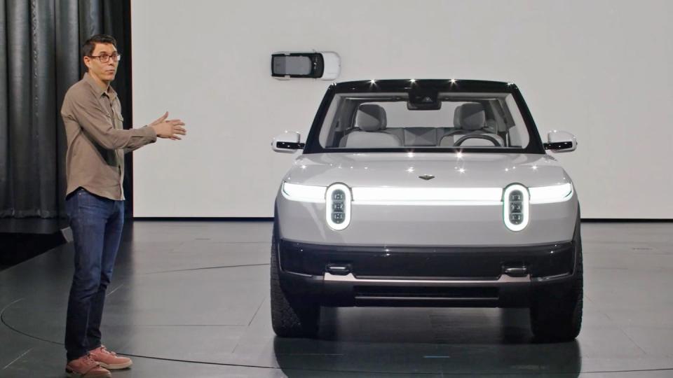rj scaringe standing next to a rivian r2