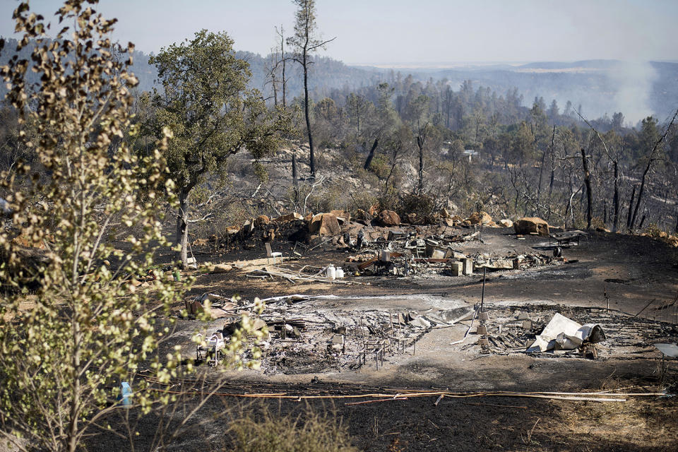 <p>The remains of a recreational vehicle rest in a clearing after a wildfire burned through the property on Saturday, July 8, 2017, near Oroville, Calif. The fire south of Oroville was one of more than a dozen burning in the state as firefighters worked in scorching temperatures to control unruly flames. (AP Photo/Noah Berger) </p>