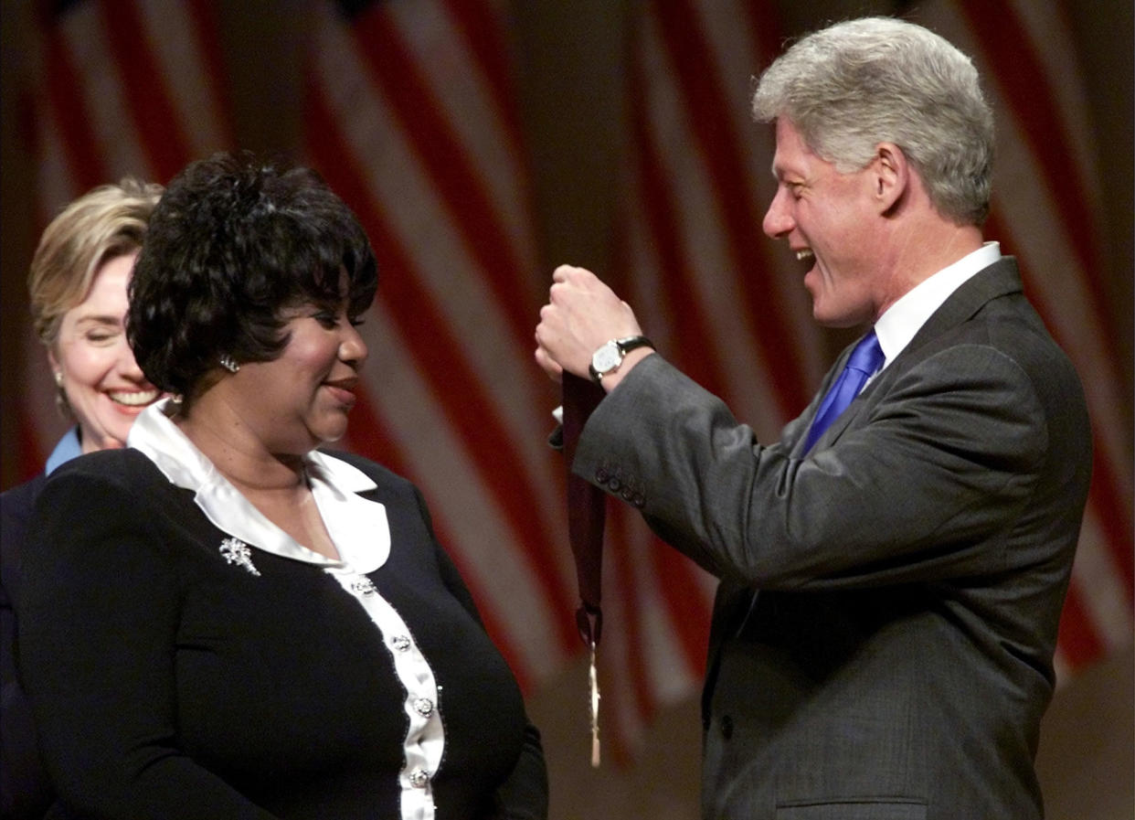 President Bill Clinton awards singer Aretha Franklin with a National Medal of the Arts in 1999 as first lady Hillary Clinton looks on.