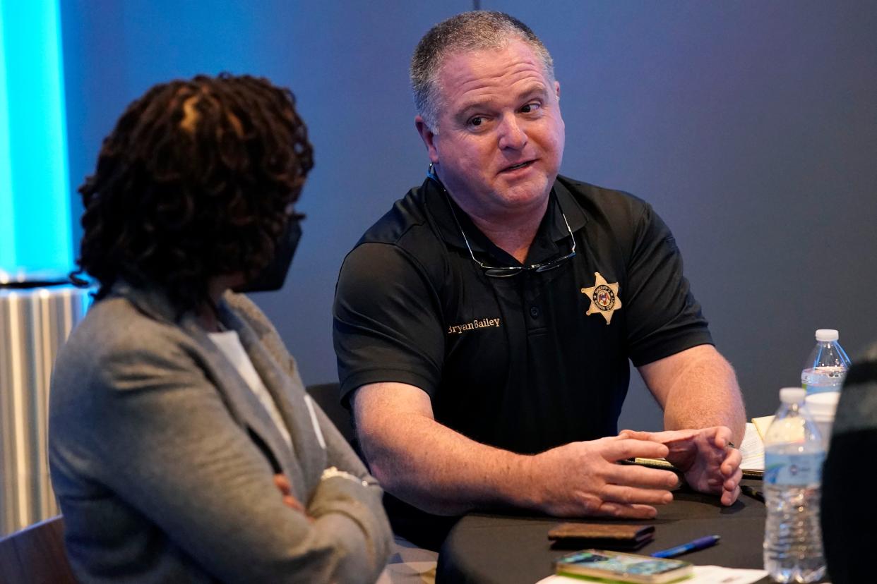 Rankin County Sheriff Bryan Bailey, right, speaks to an attendee at an employer engagement forum in Jackson, Miss., Nov. 4, 2021.