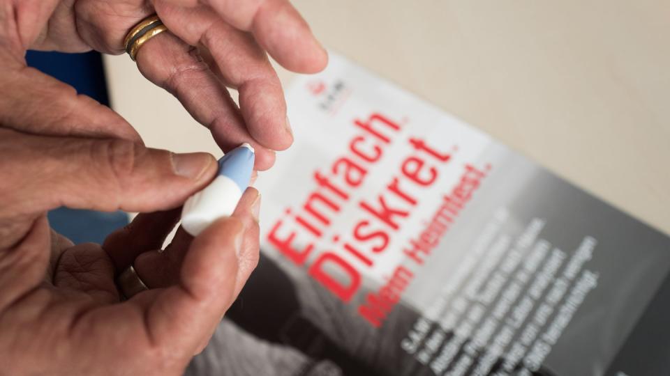 Ein Mann macht einen Heimtest auf Geschlechtskrankheiten. In Deutschland ist Syphilis wieder auf dem Vormarsch. Foto: Jörg Carstensen/Symbolbild