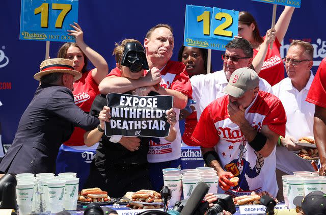 Tayfun Coskun/Anadolu Agency via Getty Joey Chestnut restrained a protestor who interrupted the 2022 Nathan's Famous Annual Hot Dog Eating Contest.