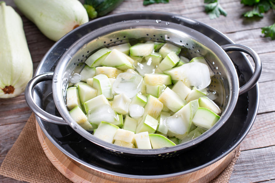 zucchini that are blanching in an ice bath