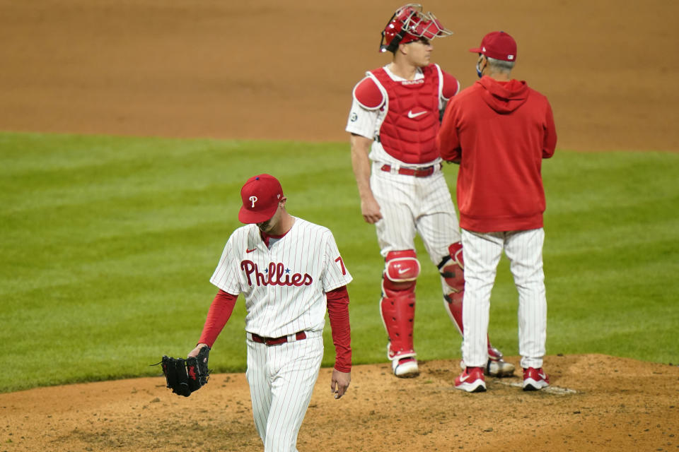 Philadelphia Phillies pitcher Connor Brogdon, left, walks to the dugout after being pulled during the eighth inning of a baseball game against the San Francisco Giants, Tuesday, April 20, 2021, in Philadelphia. (AP Photo/Matt Slocum)