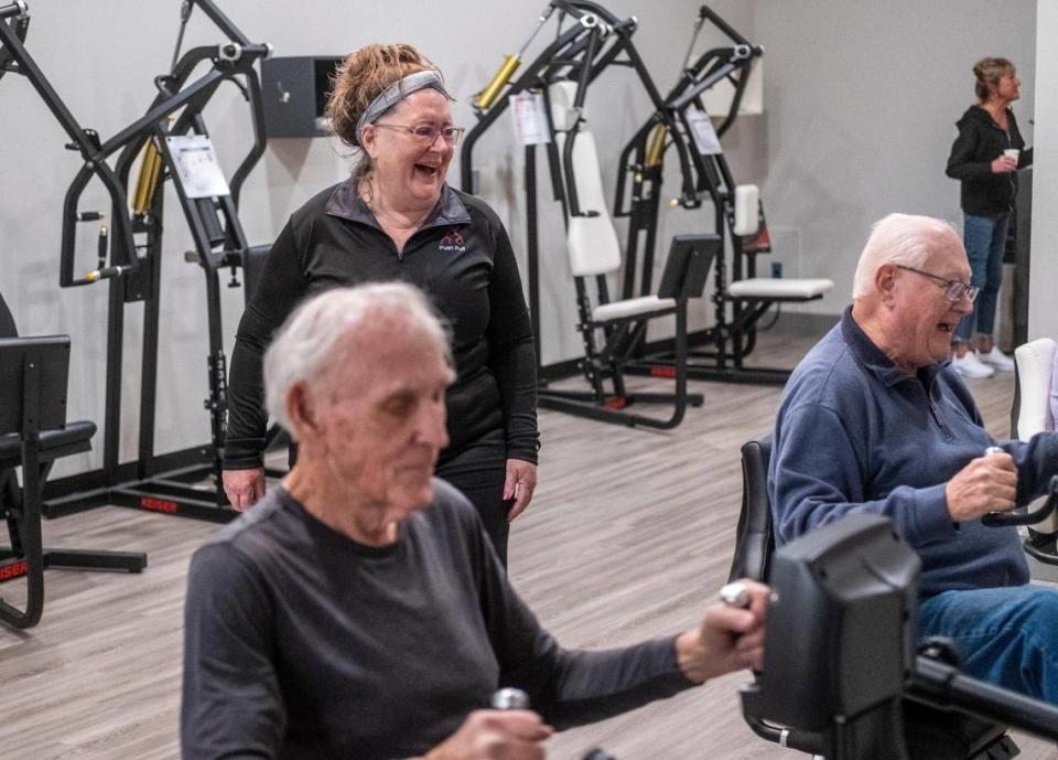Brenda Hoffman jokes with clients as they work out a the Push Pull Resistance Training for Seniors gym operated by she and her husband Greg in Little River, S.C. The gym offers personalized strength training workouts with air resistance machines to help seniors stay active. February 3, 2023.