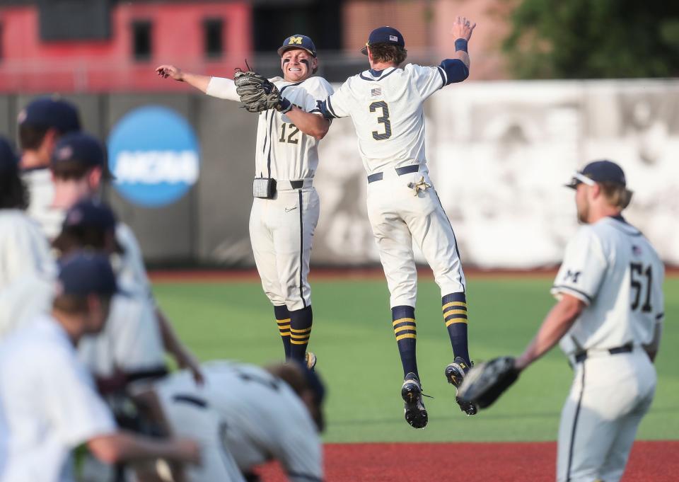 Michigan's Ted Burton and Riley Bertram, left, celebrate the Wolverines' 7-3 win over Louisville in the 2022 NCAA Regional Saturday. June 4, 2022