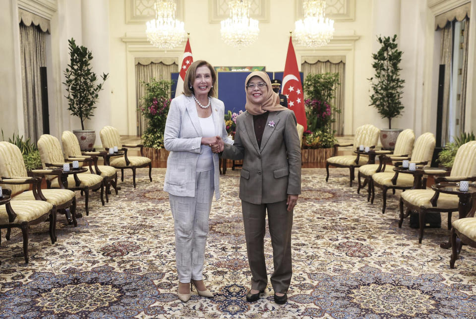 In this photo provided by Ministry of Communications and Information, Singapore, U.S. House Speaker Nancy Pelosi, left, and Singapore President Halimah Yacob shake hands at the Istana Presidential Palace in Singapore, Monday, Aug. 1, 2022. Pelosi arrived in Singapore early Monday, kicking off her Asian tour as questions swirled over a possible stop in Taiwan that has fueled tension with Beijing. (Ministry of Communications and Information, Singapore via AP)