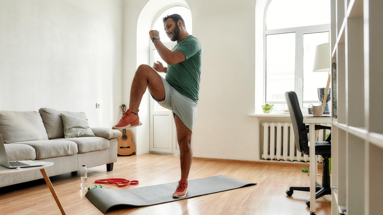  Man doing a standing abs workout at home 