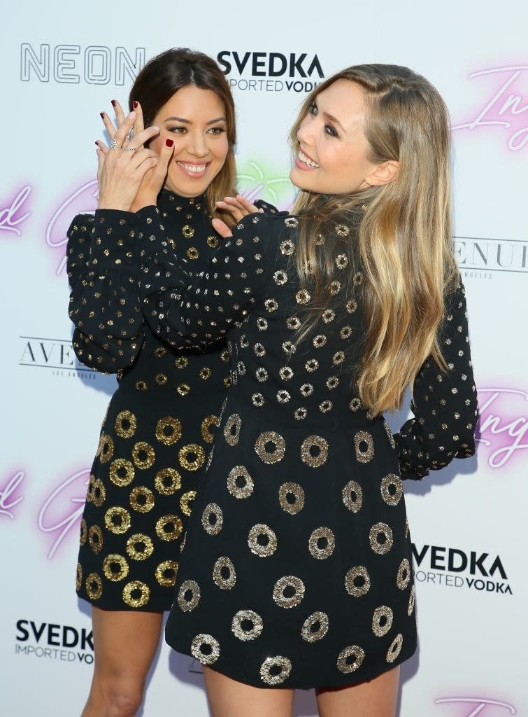 elizabeth trying to block aubrey getting photographed on the red carpet in a playful way
