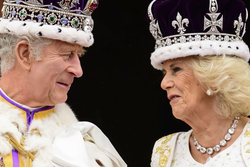 Britain’s King Charles III and Queen Camilla look at each other as they stand on the balcony of Buckingham Palace after their coronation, in London.