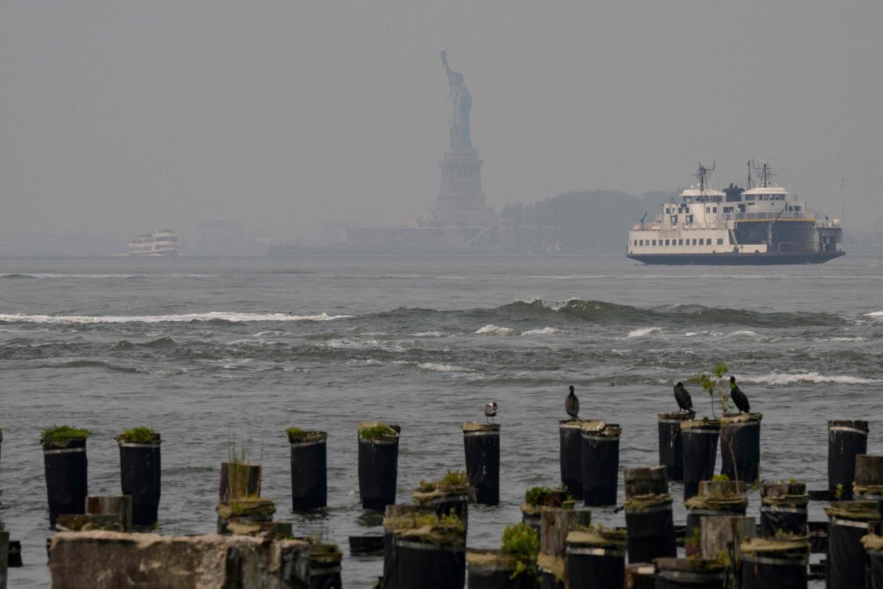 The Statue of Liberty is seen through smoke as wildfires in Canada cause hazy conditions in New York City on June 7, 2023. Smoke from Canada's wildfires has engulfed the Northeast and Mid-Atlantic regions of the US, raising concerns over the harms of persistent poor air quality.