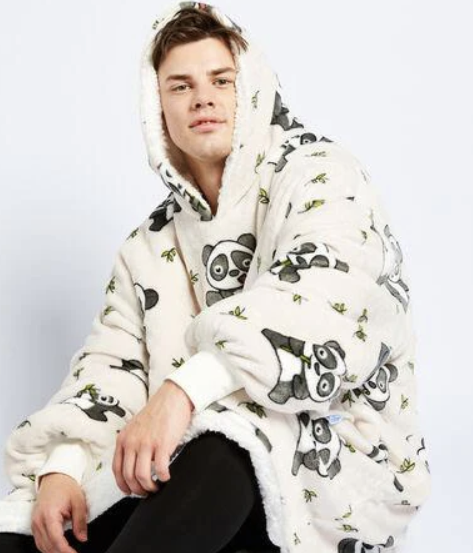 A young man sits casually in off white Oodie featuring panda and bamboo shoot prints