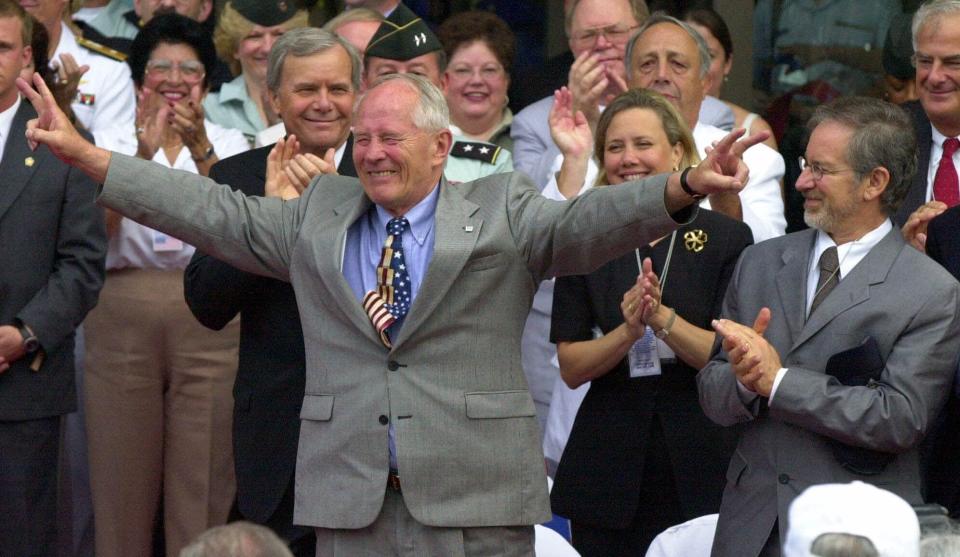 FILE- In this June 6, 2020 file photo, an emotional Stephen Ambrose, the National D-Day Museum founder, acknowledges applause as he is introduced at opening ceremonies for the museum in New Orleans. Director Steven Spielberg applauds at right as Tom Brokaw of NBC News applauds at center left. Before the COVID-19 pandemic hit, the National WWII Museum in New Orleans was planning on a 20th anniversary crowd of thousands. The National D-Day Museum was designated the National World War II museum a few years after it opened. (AP Photo/Bill Haber, file)