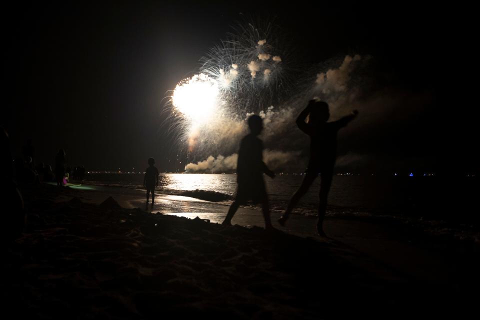 Children dance near the Naples Pier beach at the city's 2018 New Year's Eve fireworks display. The popular event has been canceled for 2022.