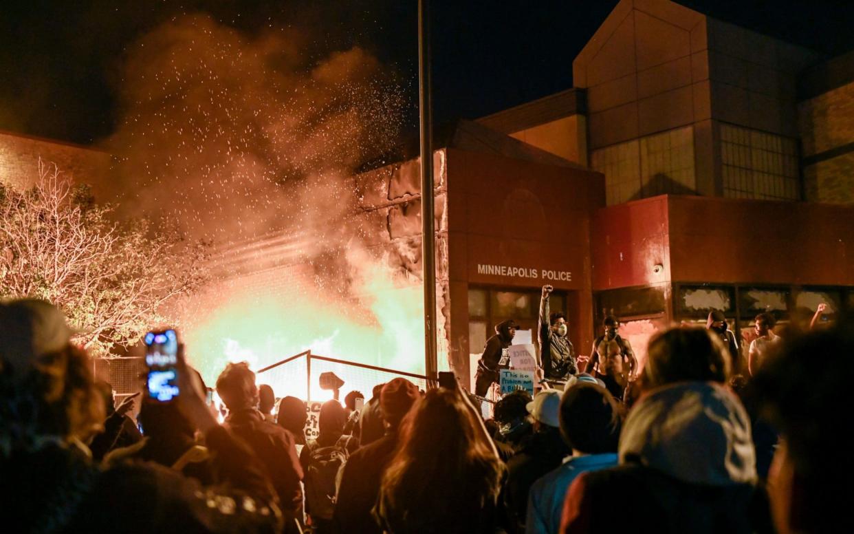 Protesters cheer as fire burns a Minneapolis police precinct during protests over the arrest of George Floyd - CRAIG LASSIG/EPA-EFE/Shutterstock