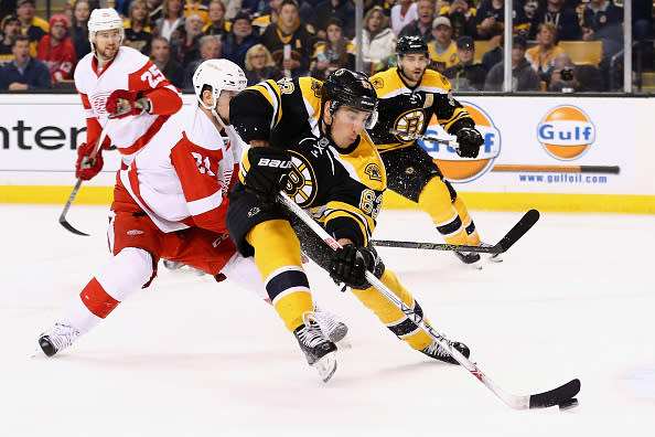 BOSTON, MASSACHUSETTS - APRIL 07: Brad Marchand #63 of the Boston Bruins looks for a shot on goal with pressure from Tomas Tatar #21 of the Detroit Red Wings during the first period at TD Garden on April 7, 2016 in Boston, Massachusetts. (Photo by Maddie Meyer/Getty Images)