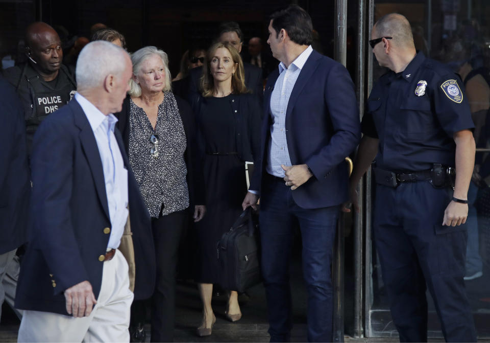 Actress Felicity Huffman, center, leaves federal court after her sentencing in a nationwide college admissions bribery scandal, Friday, Sept. 13, 2019, in Boston. (AP Photo/Elise Amendola)