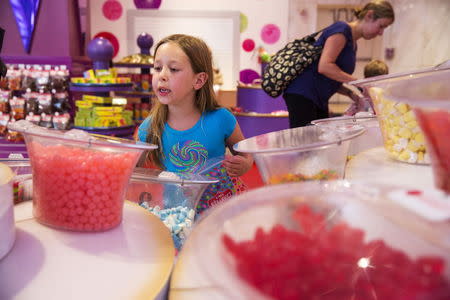 A young girl looks at the array of candy displayed inside the toy store FAO Schwarz on the last day that the store will be open in New York, July 15, 2015. REUTERS/Lucas Jackson